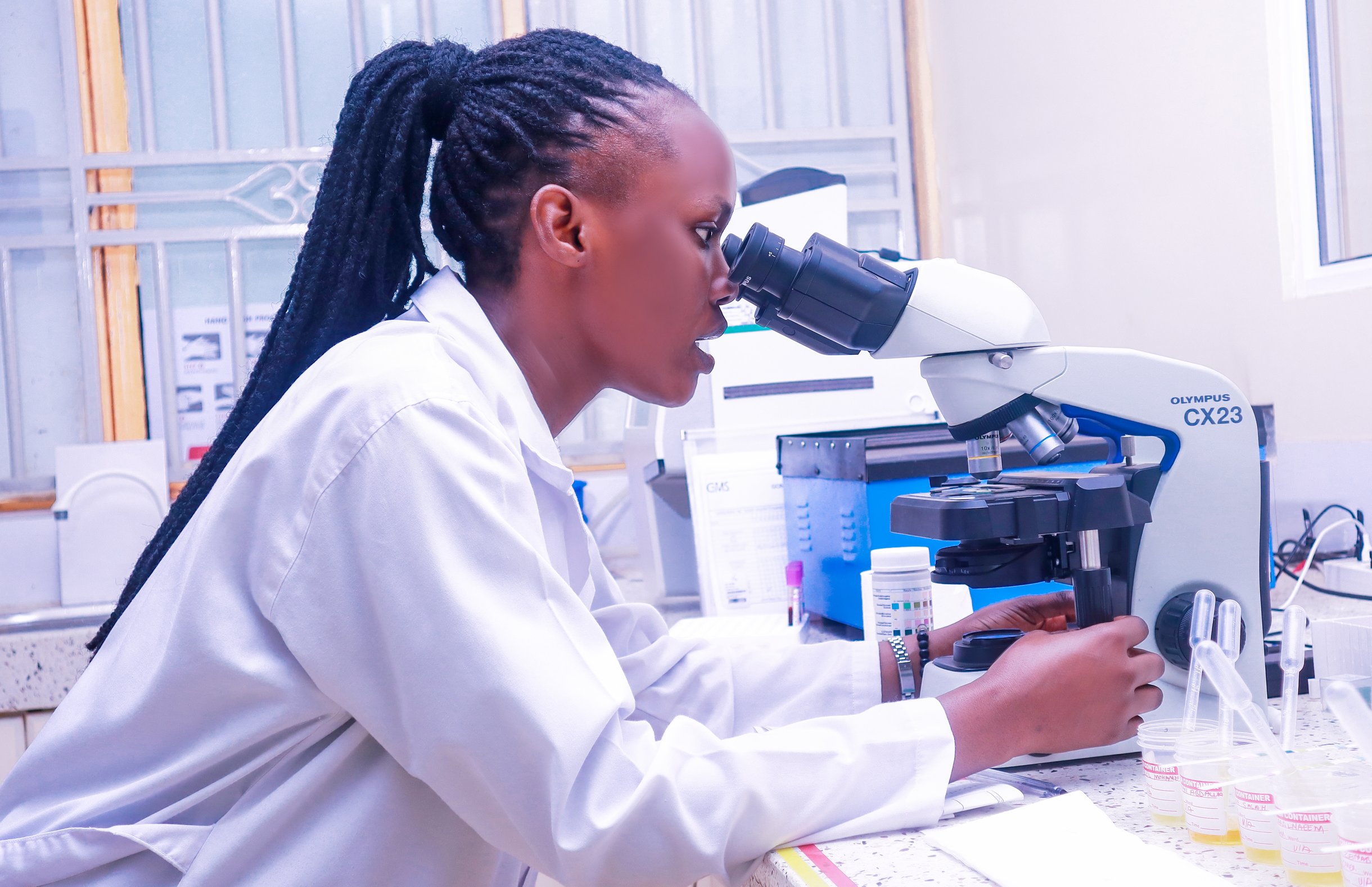 GMS laboratory professional examining samples through a microscope